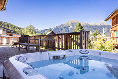 Ferienhaus mit Whirlpool auf der Veranda eines Ferienhauses im Alps Resorts Almdorf Hohentauern