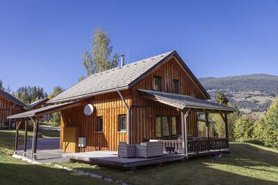 Chalet mit Veranda mit Lounge-Set und Gartenmöbeln im Alps Resorts Almdorf Stadl