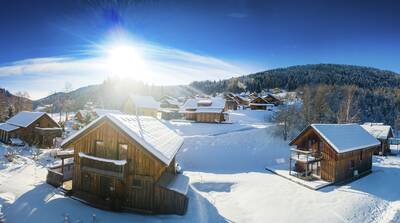 Freistehende Holzchalets im Schnee im Alps Resorts Almdorf Stadl