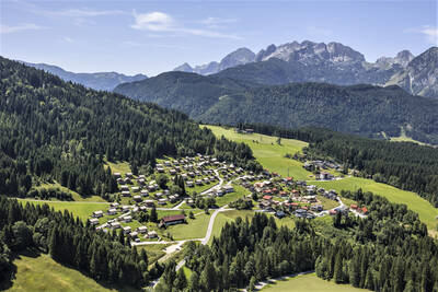 Luftaufnahme der Chalets im Alps Resorts Alpendorf Dachstein West und der Berge