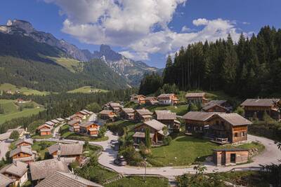 Luftaufnahme der Chalets im Alps Resorts Alpendorf Dachstein West, mit Bergen dahinter