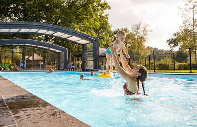 Menschen schwimmen im Außenpool des Camping de Norgerberg