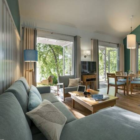 Wohnzimmer mit Essbereich und Fernseher eines Ferienhauses im Center Parcs Le Lac d'Ailette