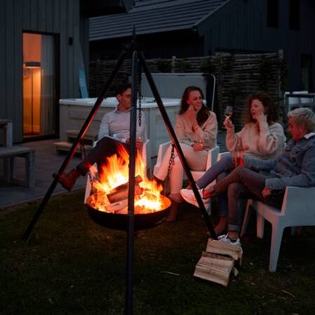 Menschen an einer Feuerstelle im Garten eines Ferienhauses bei Dutchen Baayvillas