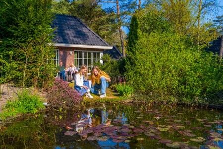 Familie im Garten eines Ferienhauses am Wasser im Ferienpark EuroParcs Beekbergen