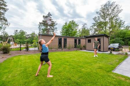 Kinder spielen Badminton im Garten eines Ferienhauses bei EuroParcs De Hooge Veluwe