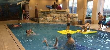 Menschen schwimmen im Hallenbad im Ferienpark EuroParcs De Rijp
