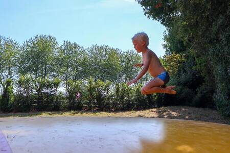 Kind springt auf dem Lufttrampolin im Ferienpark EuroParcs Marina Strandbad
