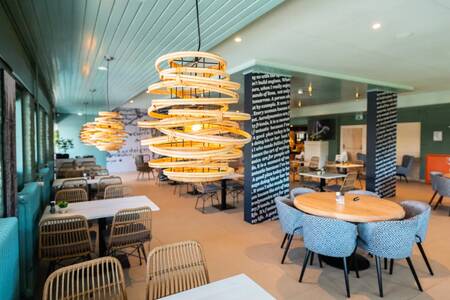 Tische mit Stühlen im stimmungsvollen Restaurant im Ferienpark EuroParcs Schoneveld