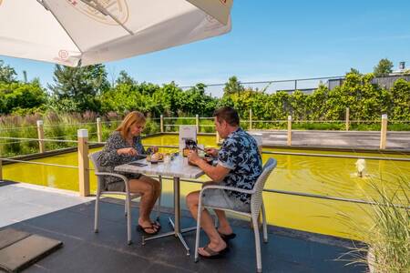 Paar isst auf der Terrasse des Restaurants des Ferienparks EuroParcs Schoneveld