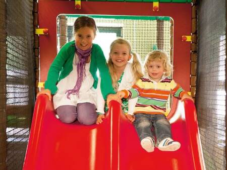 Kinder auf einer Rutsche im Indoor-Spielplatz des Ferienparks Landal De Vers