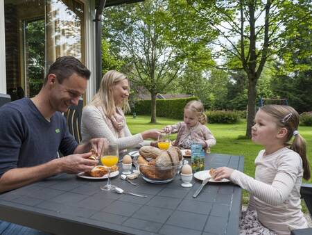 Familienfrühstück im Garten eines Ferienhauses im Ferienpark Landal Aelderholt