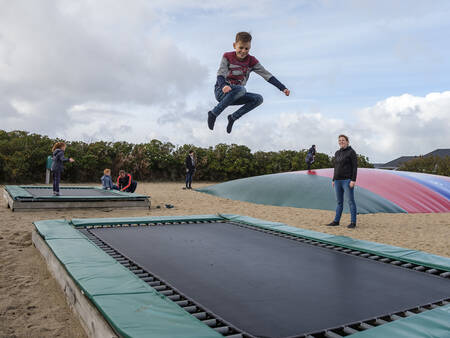 Kinder springen auf Trampolinen auf dem Spielplatz im Landal Beach Park Grønhøj Strand