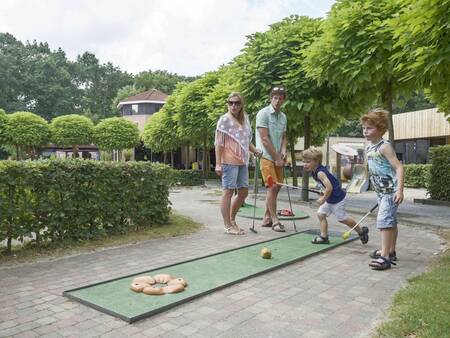 Eine Familie spielt Minigolf im Ferienpark Landal De Vers