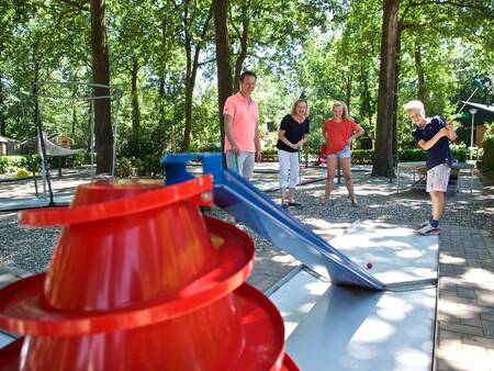 Familie spielt Golf auf dem Minigolfplatz im Ferienpark Landal Heihaas