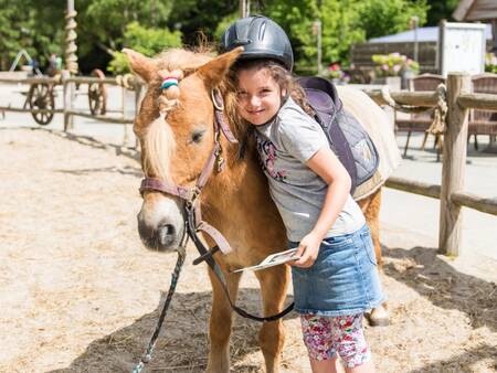 Mädchen mit Pony auf dem Ponyhof des Ferienparks Landal Het Land van Bartje