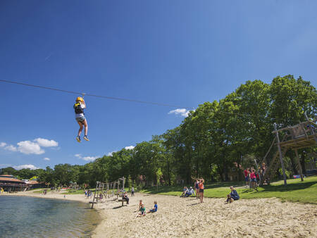 Junge auf der Seilrutsche über den Freizeitsee im Ferienpark Landal Landgoed 't Loo