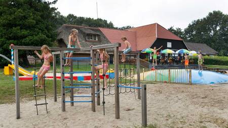 Kinder spielen auf dem Spielplatz mit Lufttrampolin im Molecaten Park De Agnietenberg