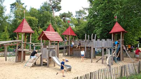 Kinder spielen auf einem großen Spielplatz im Ferienpark Molecaten Park Landgoed Ginkelduin