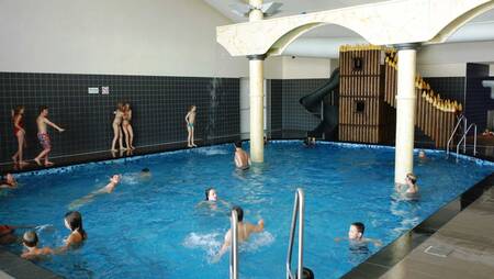 Menschen schwimmen im Hallenbad des Ferienparks Molecaten Park Noordduinen
