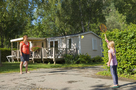 Mutter und Tochter spielen Badminton vor einem Mobilheim im Ferienpark RCN Belledonne