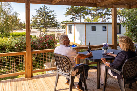 Ein Paar sitzt auf der Veranda eines Mobilheims im Ferienpark RCN Port l'Epine