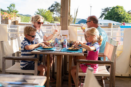Familie beim Essen auf der Terrasse des Restaurants im Ferienpark RCN Port l'Epine