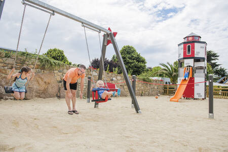 Kinder auf der Schaukel auf dem Spielplatz im Ferienpark RCN Port l'Epine