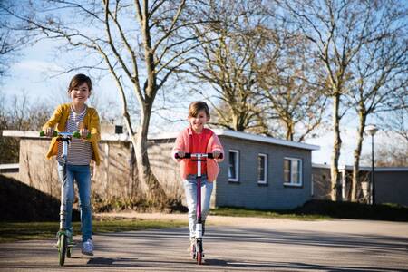 Zwei Kinderroller vor Chalets im Ferienpark RCN Toppershoedje