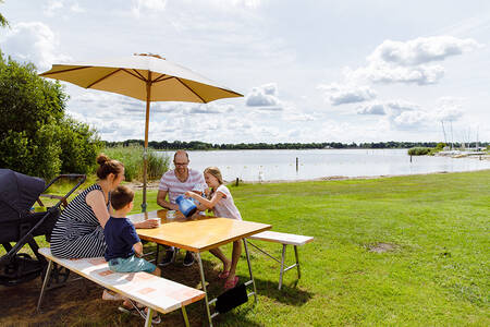 Familie an einem Picknicktisch am Veluwemeer im Ferienpark RCN Zeewolde
