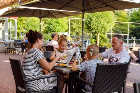 Familie isst auf der Terrasse der Brasserie de Jagerstee im Ferienpark RCN de Jagerstee
