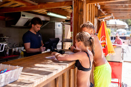 Junge und Mädchen vor der Snackbar des Ferienparks RCN les Collines de Castellane