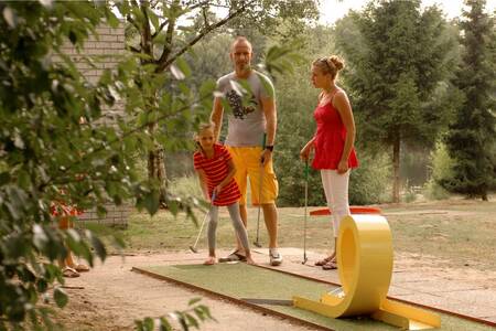 Familie spielt Golf auf dem Minigolfplatz im Ferienpark Roompot Bospark 't Wolfsven