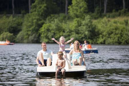Eine Familie auf einem Tretboot auf dem See neben dem Roompot Eifelpark Kronenburger See