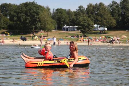 Frau mit Kind in einem Schlauchboot auf dem Erholungssee des Roompot Ferienparks Hunzedal
