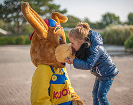 Mädchen umarmt Koos Kaninchen im Roompot Holiday Park Hunzedal
