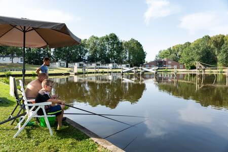 Menschen, die im Ferienpark Roompot Hunzepark im Wasser fischen