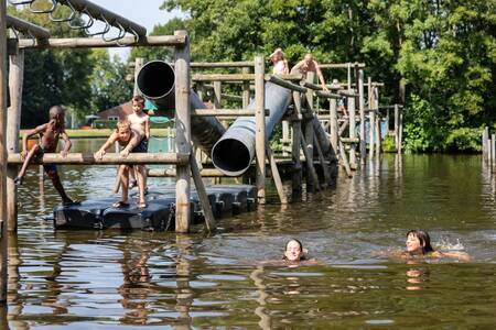 Kinder spielen im Wasser auf einem Spielplatz im Ferienpark Roompot Hunzepark