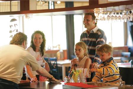 Familie an der Bar in einem Restaurant im Ferienpark Roompot Kustpark Texel