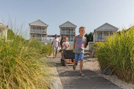 Familienspaziergang durch Strandhafer an den Ferienhäusern im Roompot Nordsee Résidence De Banjaard