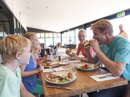 Familie beim Essen in einem Strandpavillon in der Nähe von Roompot Strandhuisjes Julianadorp
