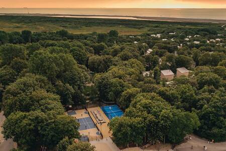 Luftaufnahme mit Tennisplatz, Spielfeld und Ferienhäusern im Roompot Vakantiepark Kijkduin