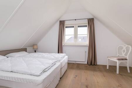Schlafzimmer mit Doppelbett in einem Ferienhaus im Roompot Villaparc Schoonhovenselland