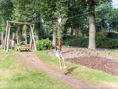 Mädchen auf der Seilbahn auf einem Spielplatz im Ferienpark Topparken Landgoed de Scheleberg