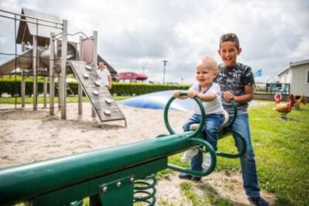 Kinder auf einer Wippe auf dem Spielplatz des Ferienparks Topparken Park Westerkogge
