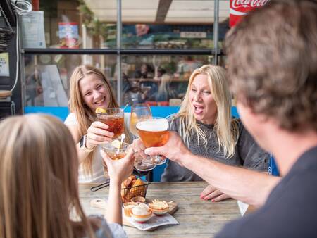 Familie genießt einen Snack und ein Getränk im Restaurant des Topparken Recreatiepark de Wielerbaan