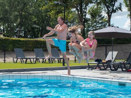 Menschen springen in das Freibad des Ferienparks Topparken Recreatiepark de Wielerbaan