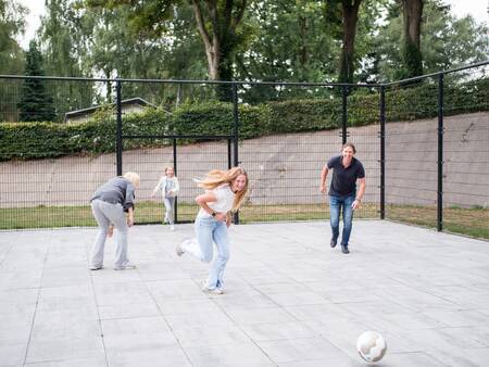 Kinder spielen Fußball auf dem Spielfeld des Ferienparks Topparken Recreatiepark de Wielerbaan