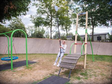 Mädchen auf der Seilbahn auf dem Spielplatz im Topparken Recreatiepark de Wielerbaan