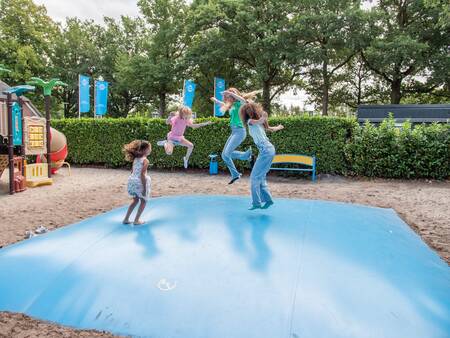 Kinder springen auf einem Lufttrampolin auf einem Spielplatz im Topparken Résidence De Leuvert